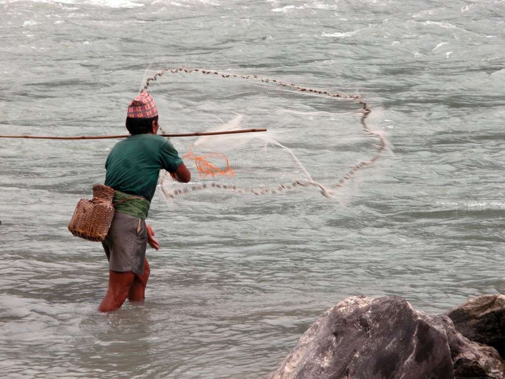 Manaslu 02 02 Fisherman I stopped and watched this local fisherman throw his net laden with some kind of shell, into the Buri Gandaki.